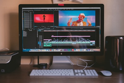 turned on iMac and Apple Magic Keyboard and mouse on table